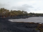 Click to enlarge black sand beach across from boat shed